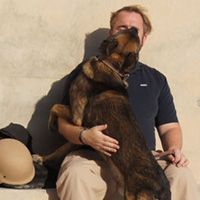 A K9 handler shares an affectionate moment with his dog